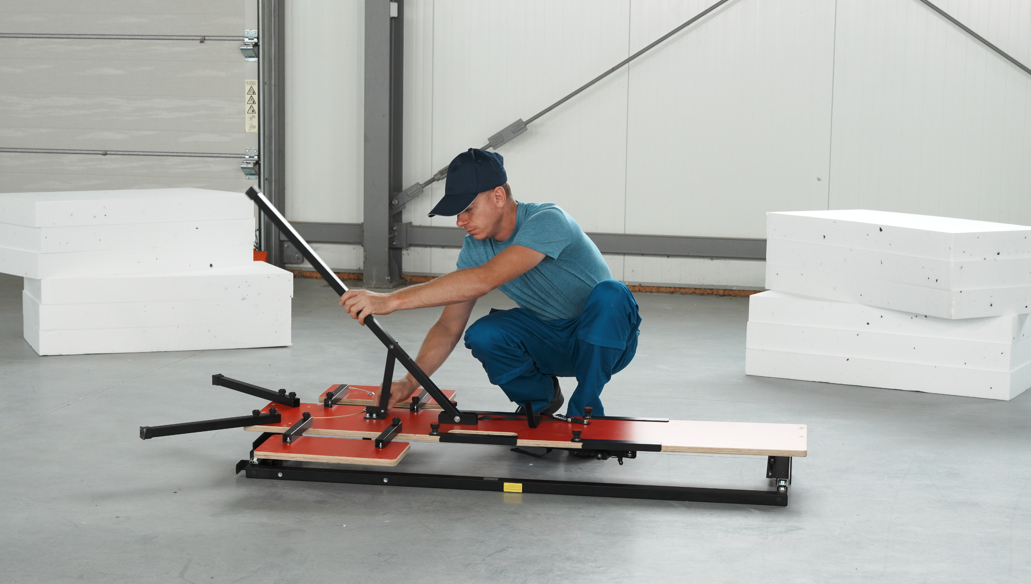 Człowiek używający maszyny do wycinania w styropianach do cięcia bloków piankowych.